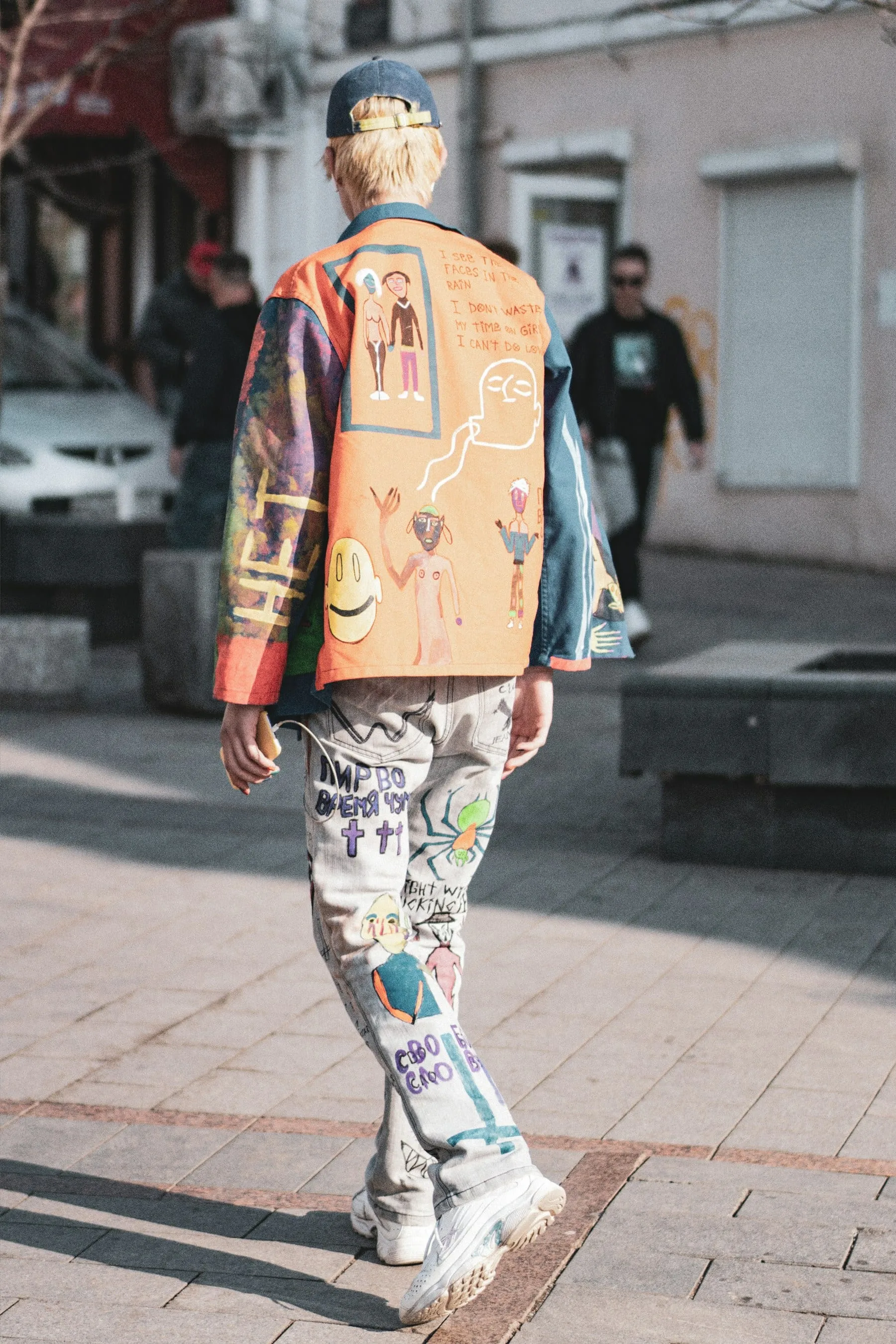 A street-style outfit with a hand-painted jacket and bold graphic trousers