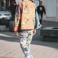 A street-style outfit with a hand-painted jacket and bold graphic trousers