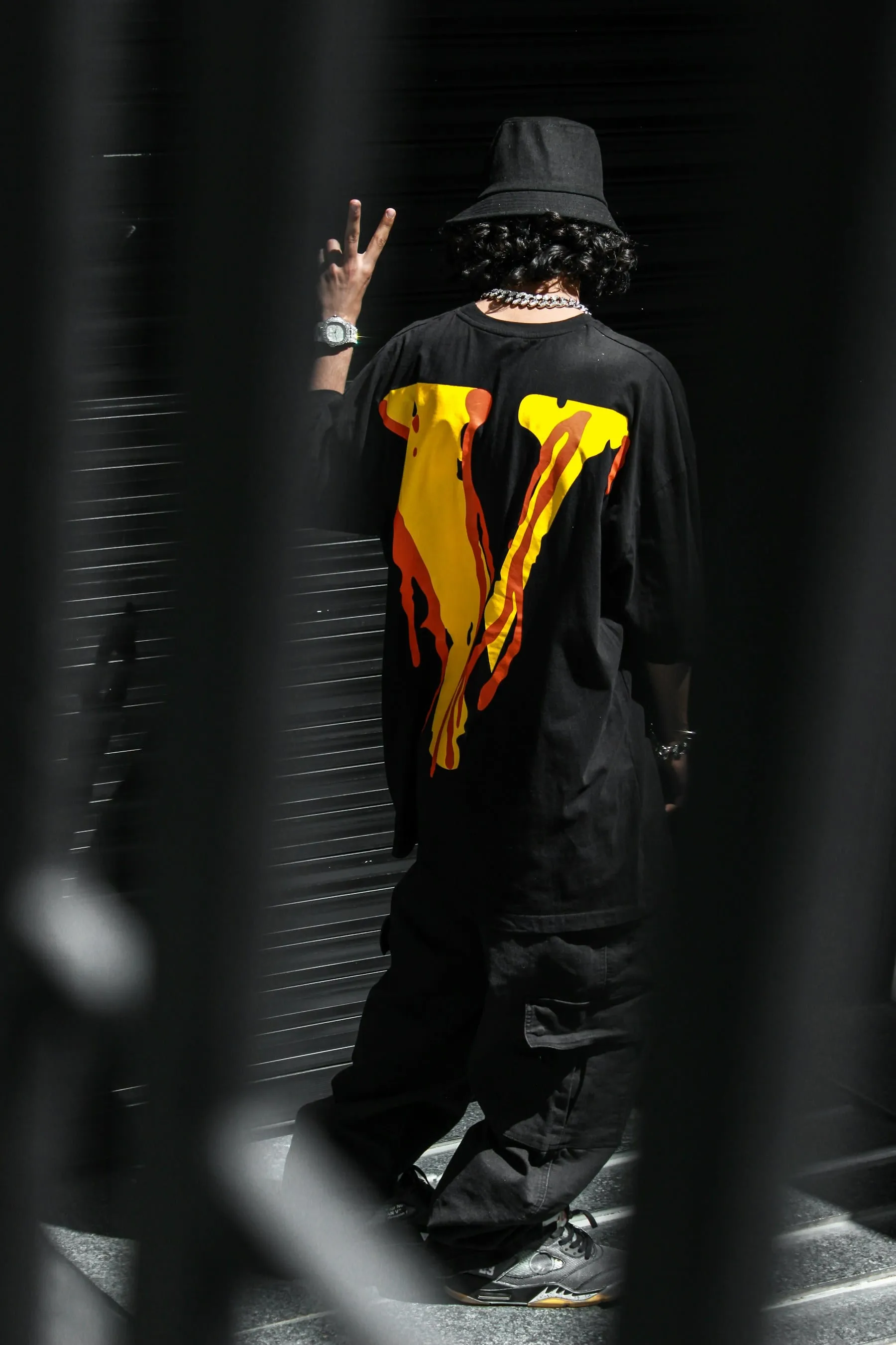 A dark streetwear look with a vivid orange and yellow graphic on the back