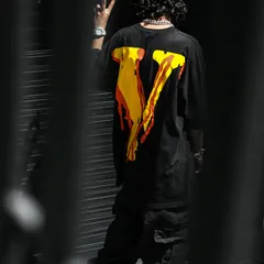 A dark streetwear look with a vivid orange and yellow graphic on the back