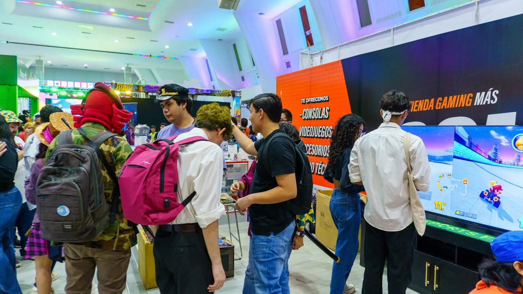 A crowd gathered around a large screen at a pop culture event