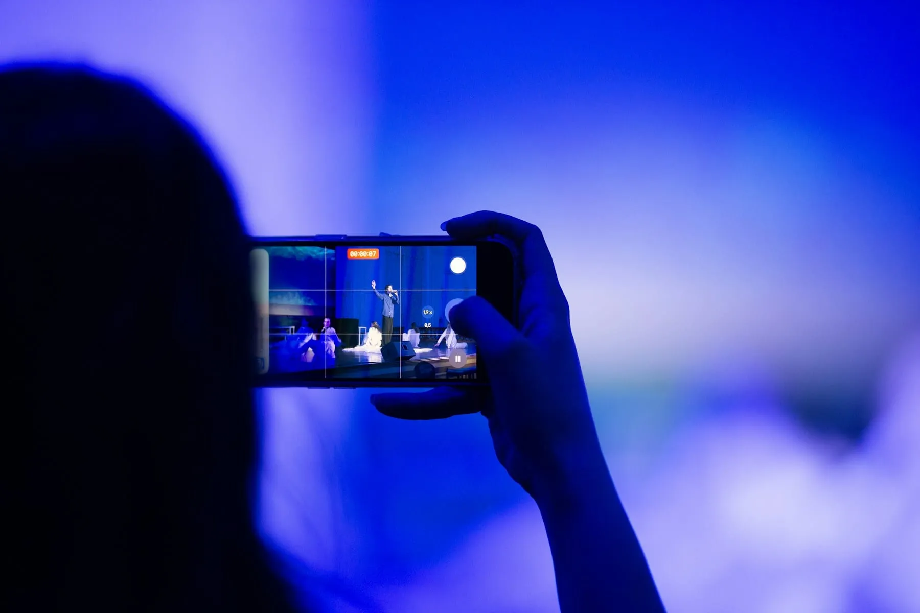 A person recording a live concert on a smartphone
